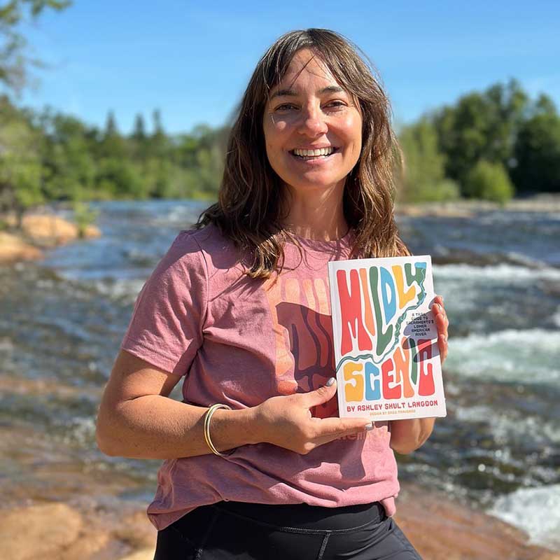 Sacramento author Ashley Shult Langdon holding a copy of her book, Mildly Scenic: A Trail Guide to Sacramento's Lower American River.