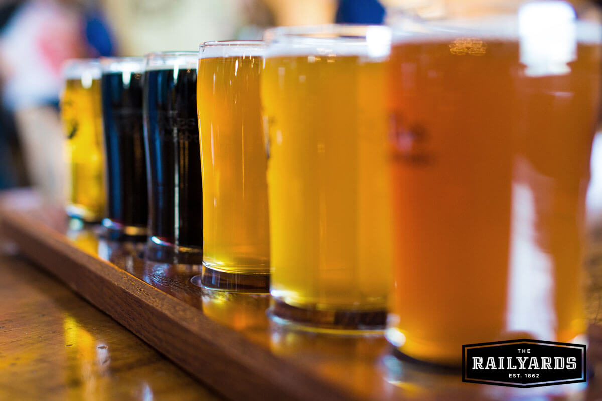 A variety of beers including dark stouts and pale ales lined up. Discover Sac's craft beer scene.