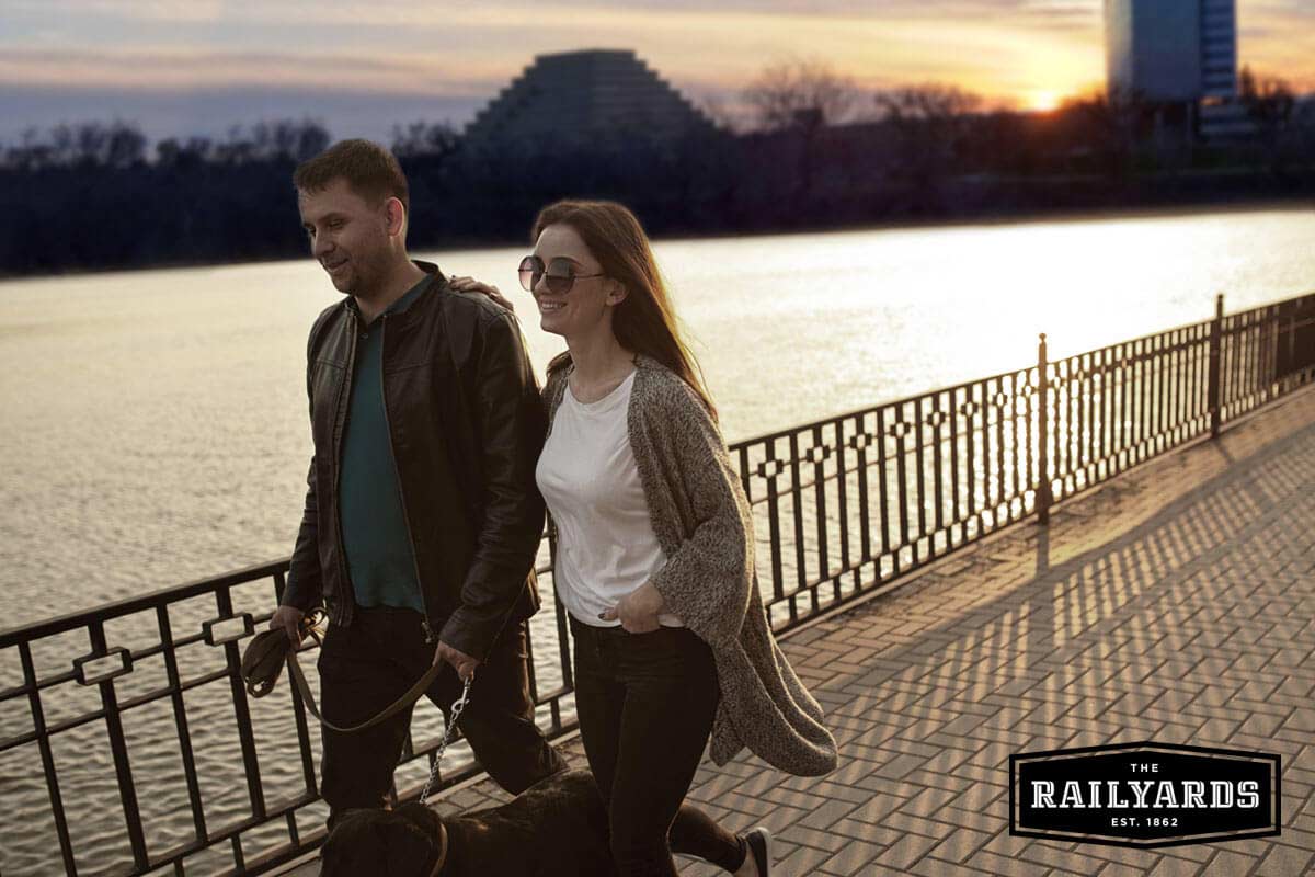 A young couple walk their dog along the river. Learn more about Sacramento's vision for the Railyards.