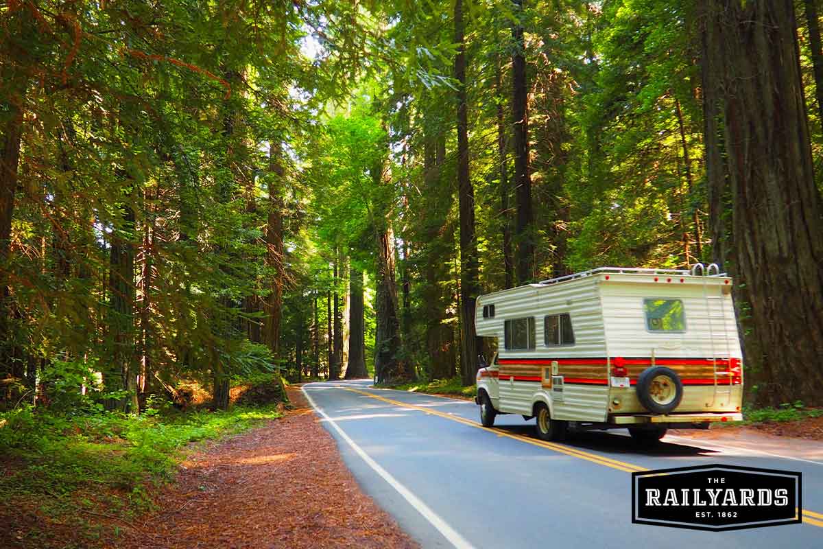RV driving through CA forest.
